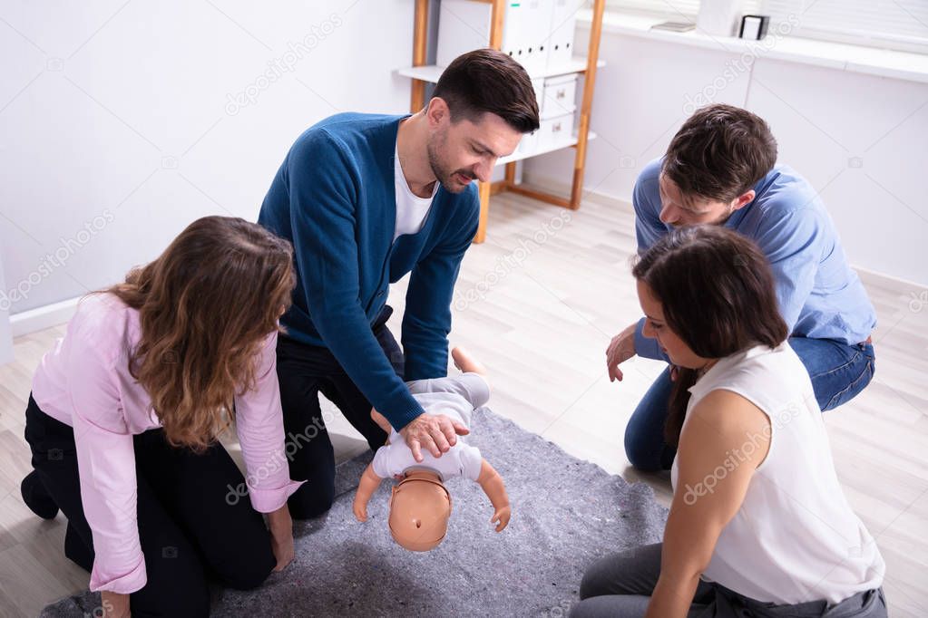Reanimationsübung bei einem Kind mit Trainingspuppe