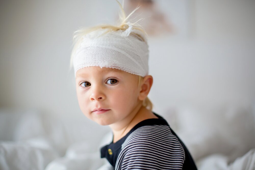 Kind gestürzt mit Helm wird getröstet