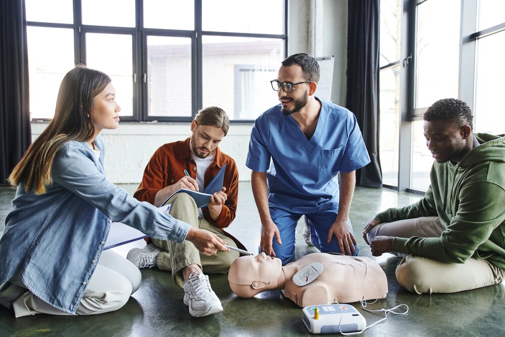 Teilnehmende üben Herzdruckmassage und AED